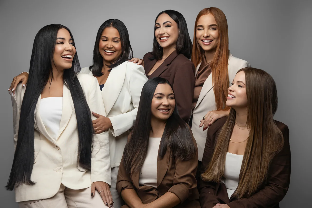 Luanna Martins com cinco mulheres sorrindo, com cabelos de diferentes tons e comprimentos